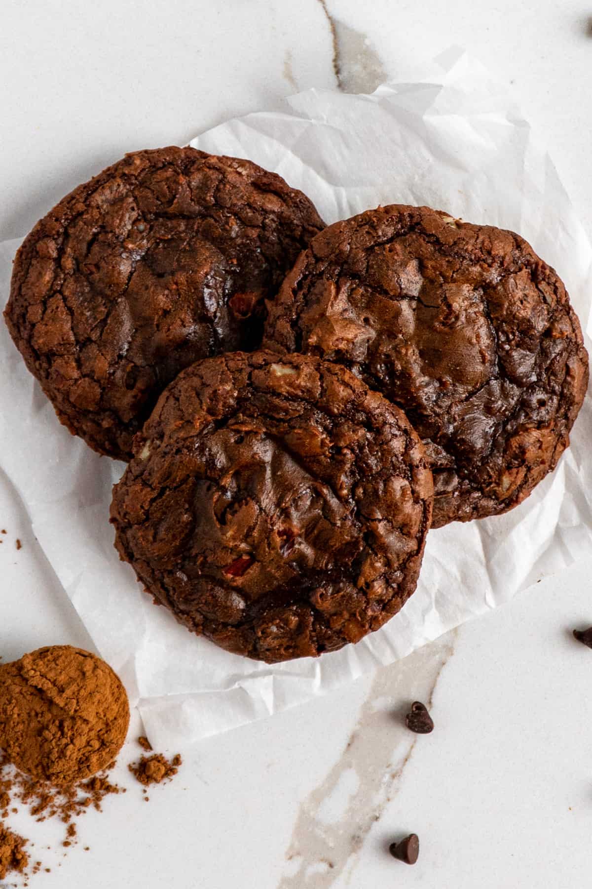 Three brownie cookies on a piece of parchment paper