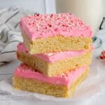 Peppermint sugar cookie bars stack on top of each other.
