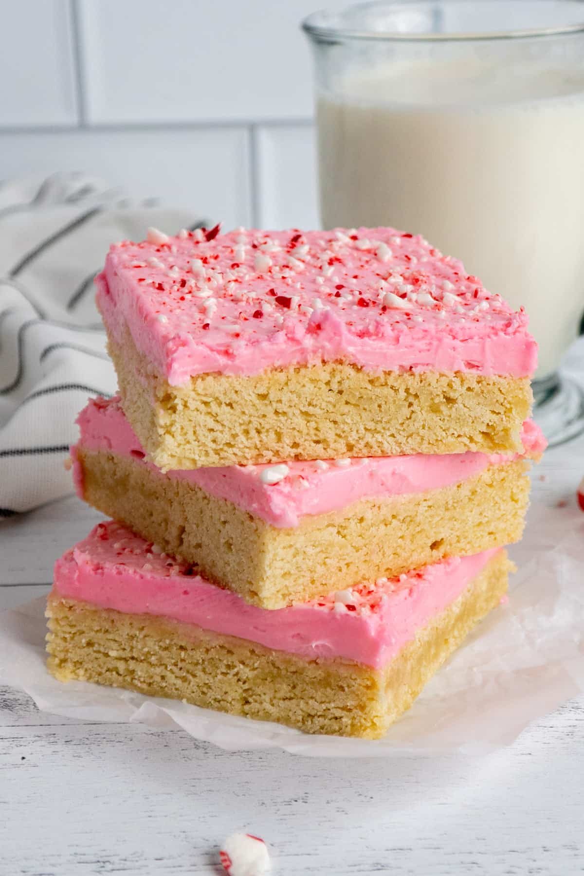 Peppermint sugar cookie bars stack on top of each other.