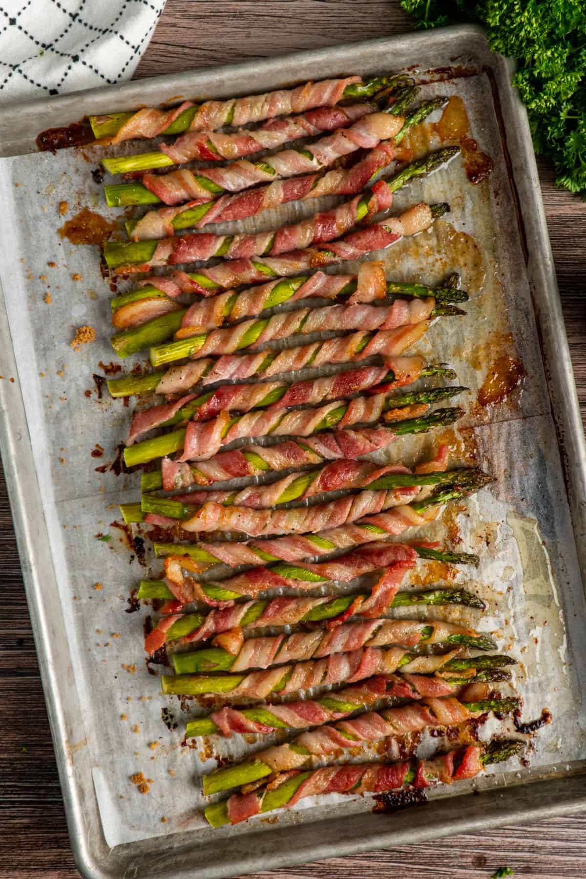 Bacon wrapped asparagus on a baking sheet.