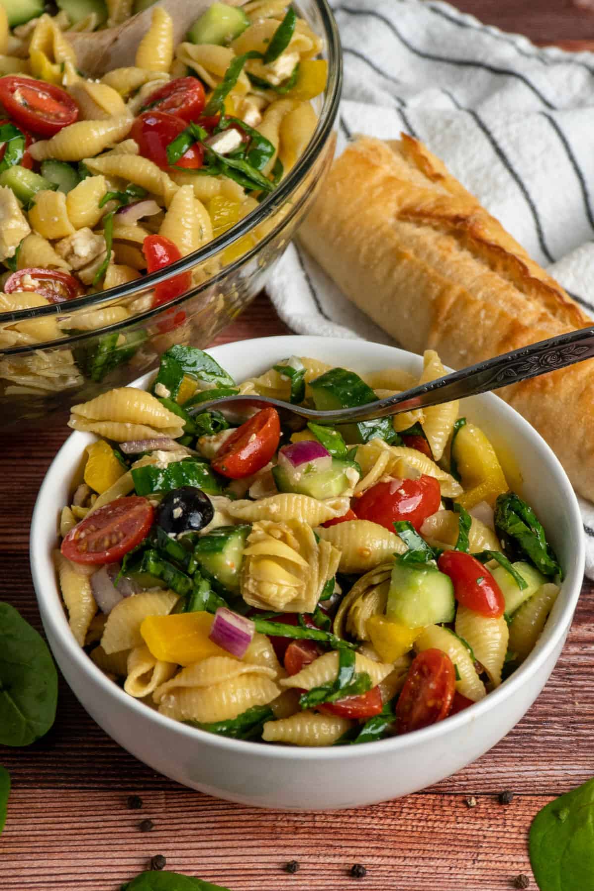 Veggies and pasta in a white bowl with a fork.