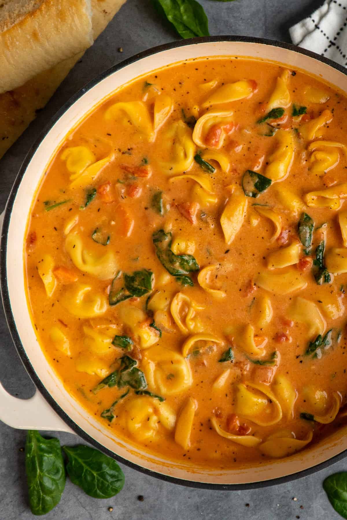 Close-up of creamy tortellini soup in a large soup pot.