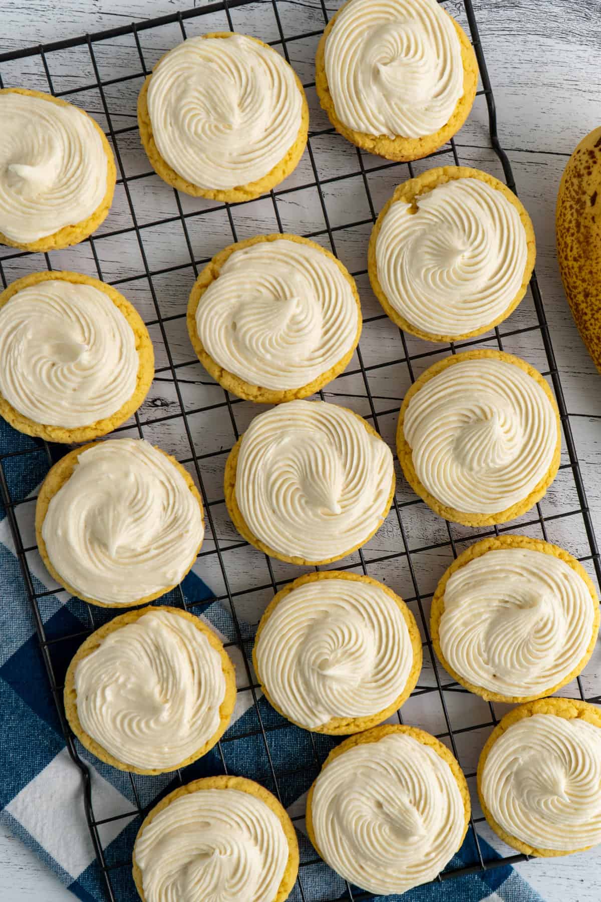 Cake mix cookies on a cooling rack with buttercream frosting.