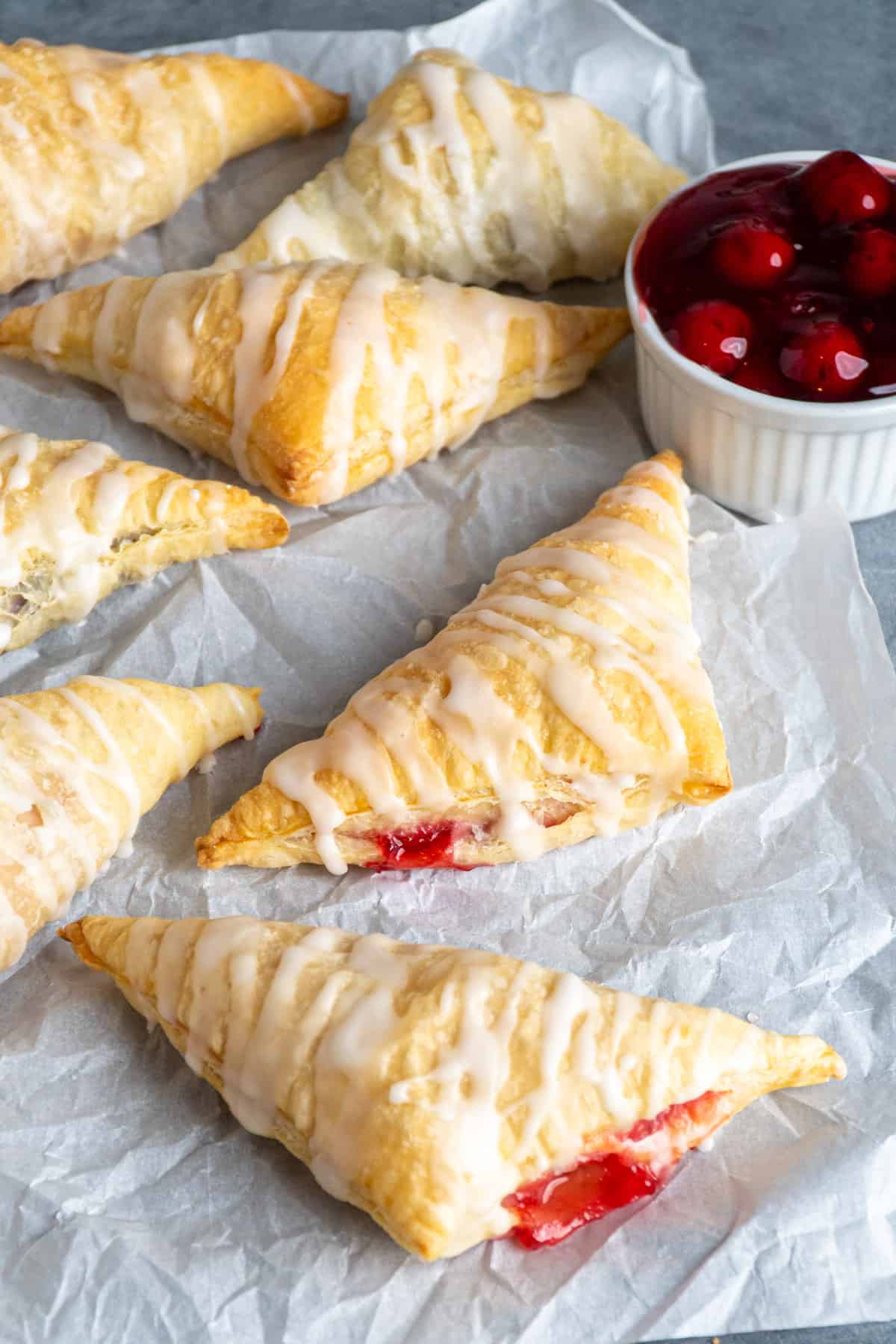 Homemade puff pastry turnovers on parchment paper.