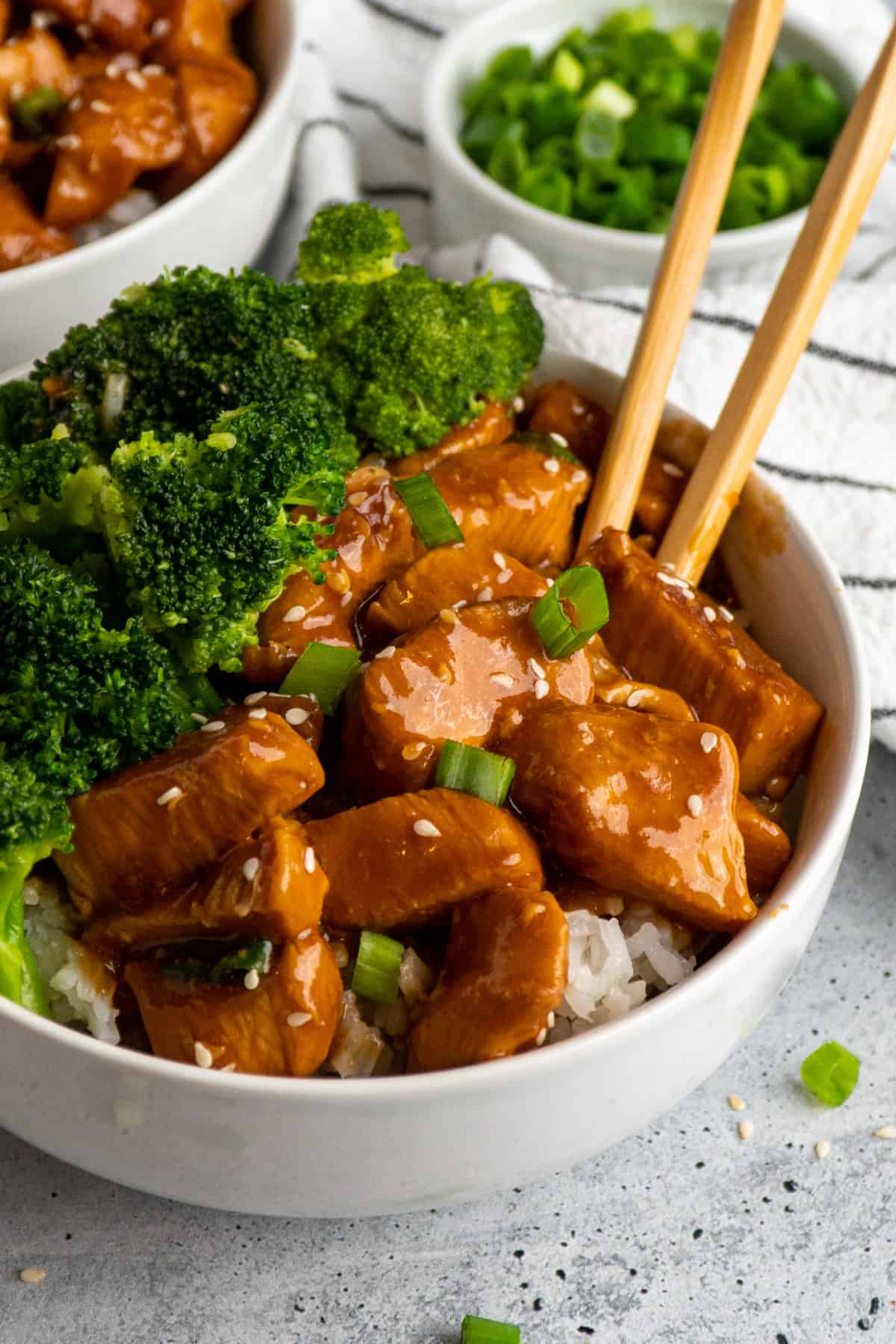 Slow cooker teriyaki chicken over a bowl of rice with broccoli.