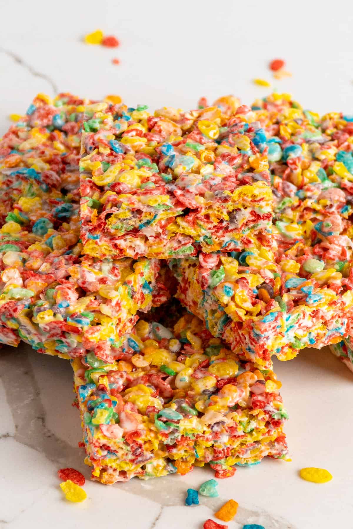An angled look of fruity pebbles rice crispy treats piled on top of each other.