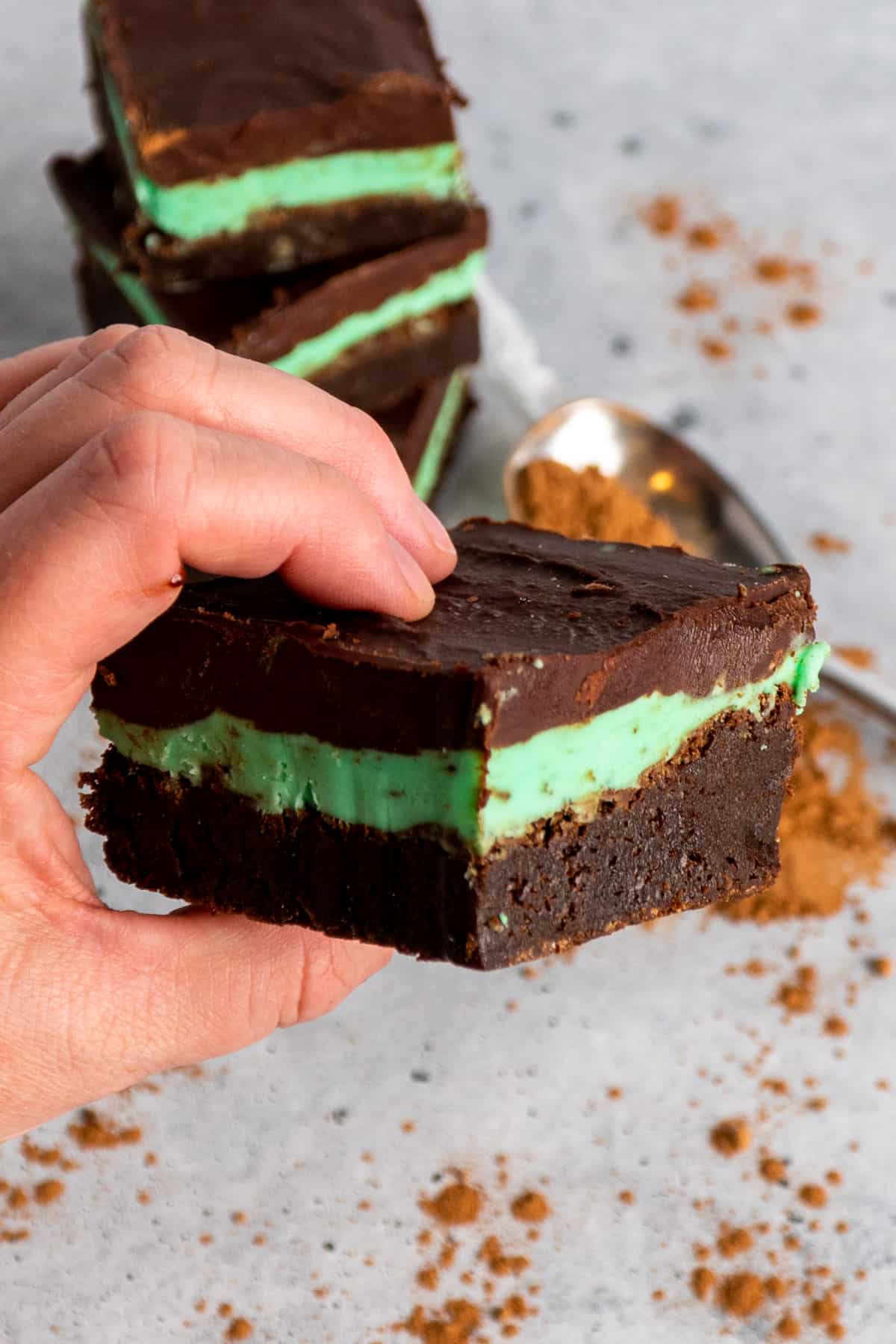 A hand holding a mint chocolate brownie.