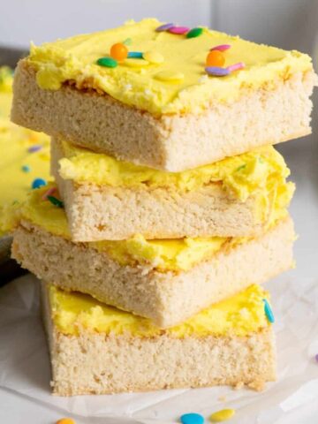 Four frosted sugar cookie bars stacked on top of each other