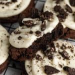 Copycat Crumbl chocolate Oreo cookies with a bite taken out on a black cooling rack.