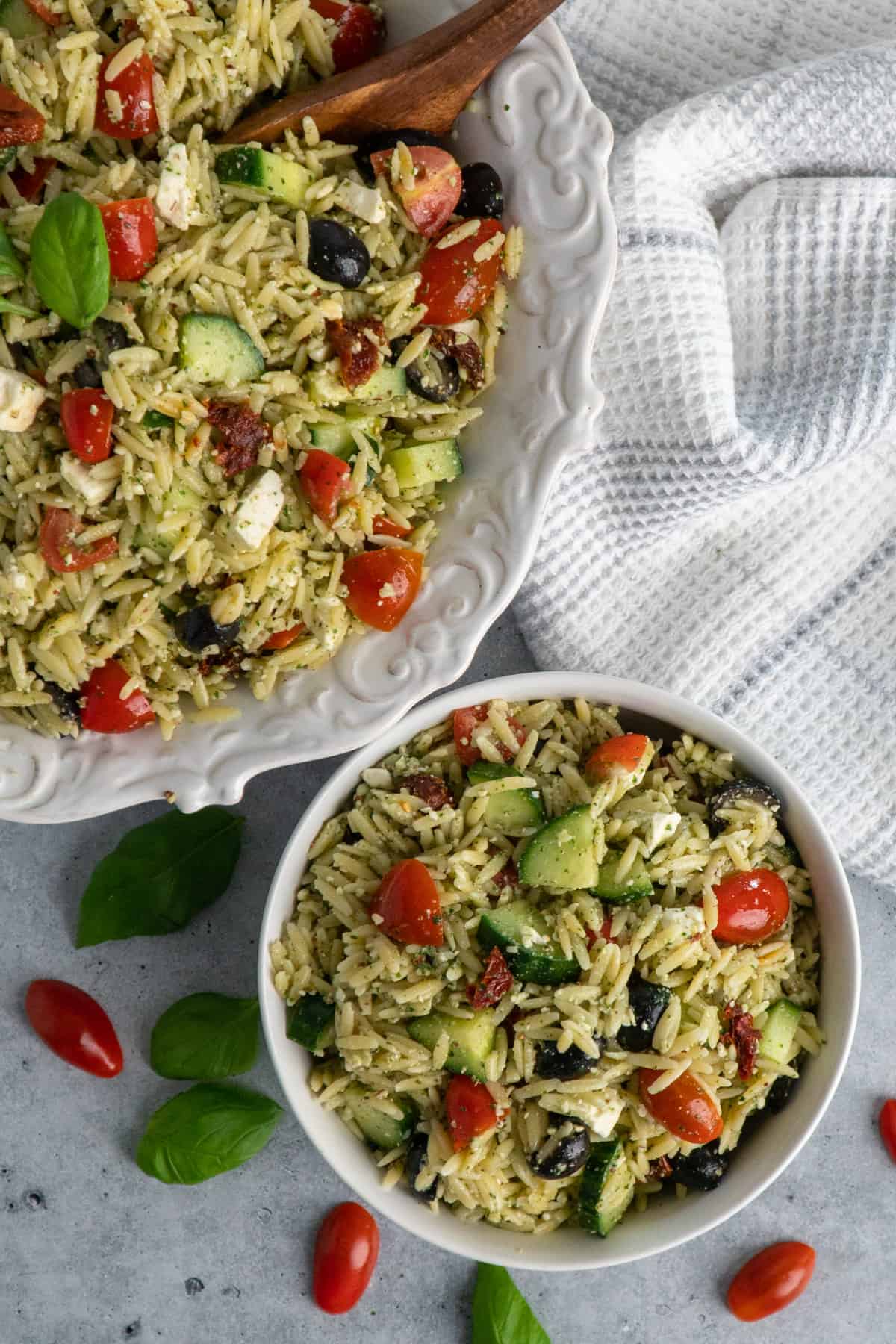An overhead look at two bowls of pesto orzo pasta salad.