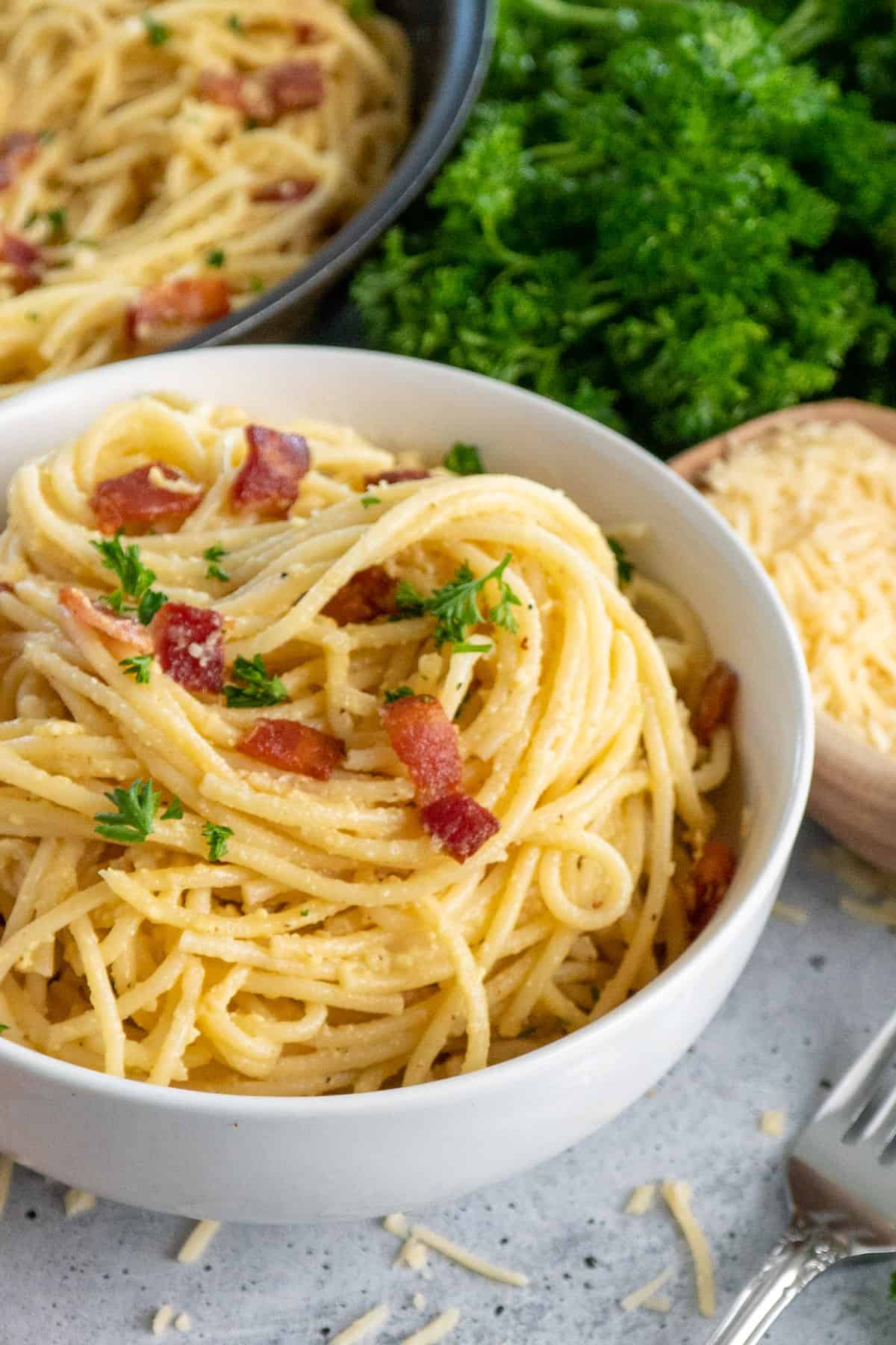 Close up of a white bowl with spagetti carbonara.