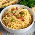Close up of a white bowl with spagetti carbonara.