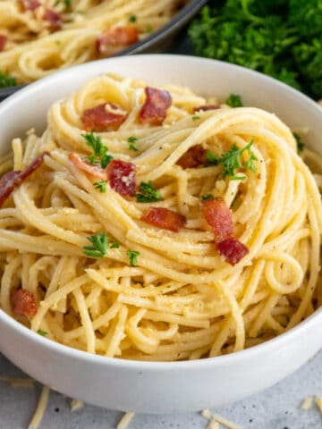 Close up of a white bowl with spagetti carbonara.