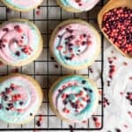 Cotton candy Crumbl cookies on a a black cooling rack.