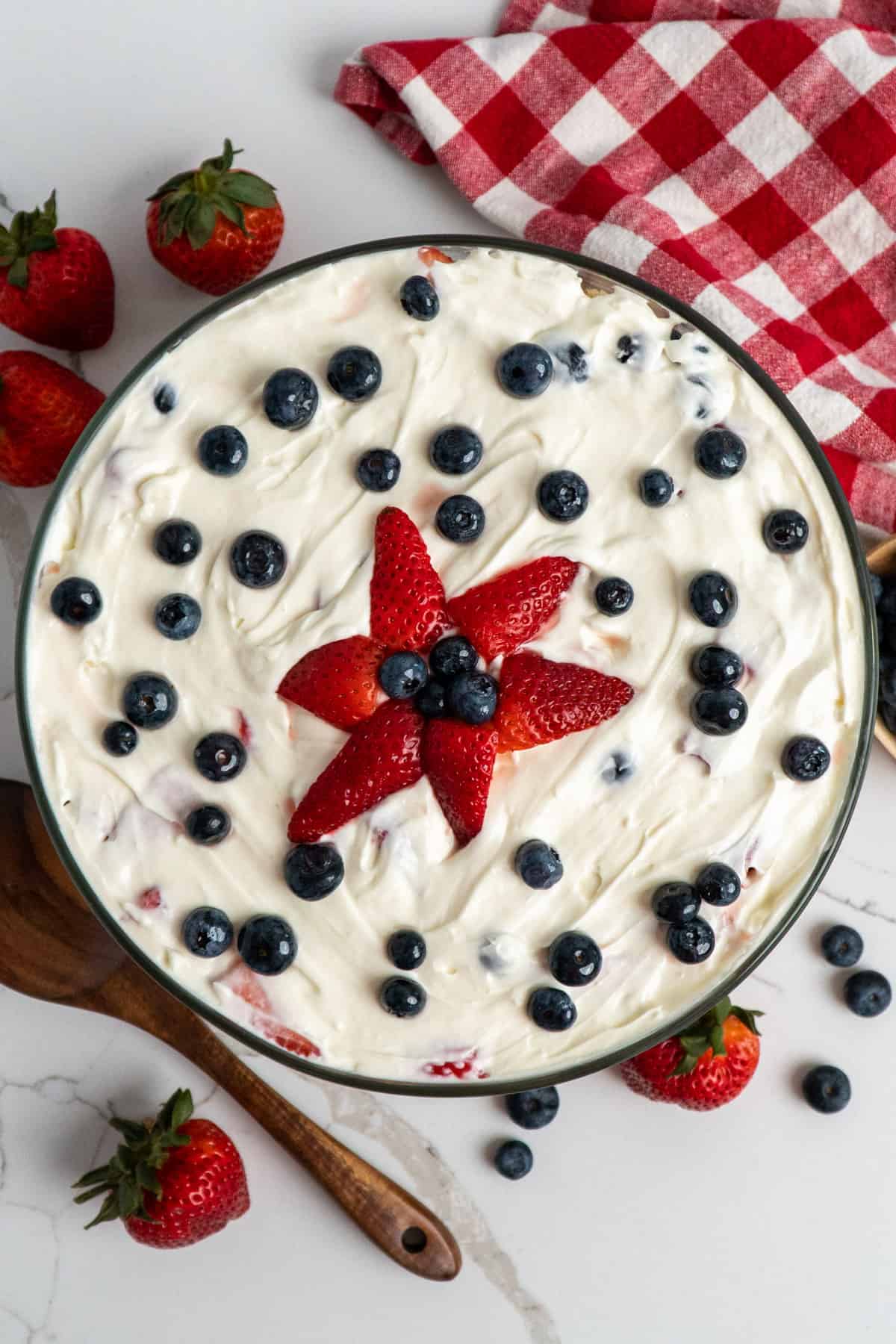 Overhead, look at a dessert with cream cheese frosting and berries on top.