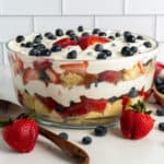Strawberry and blueberry pound cake trifle in a glass bowl.
