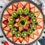 Fruit pizza with sugar cookie crust on a pizza pan.