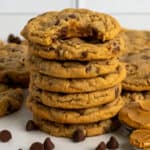 Seven peanut butter chocolate chip cookies stacked on top of each other.