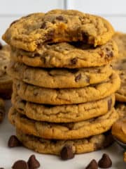 Seven peanut butter chocolate chip cookies stacked on top of each other.