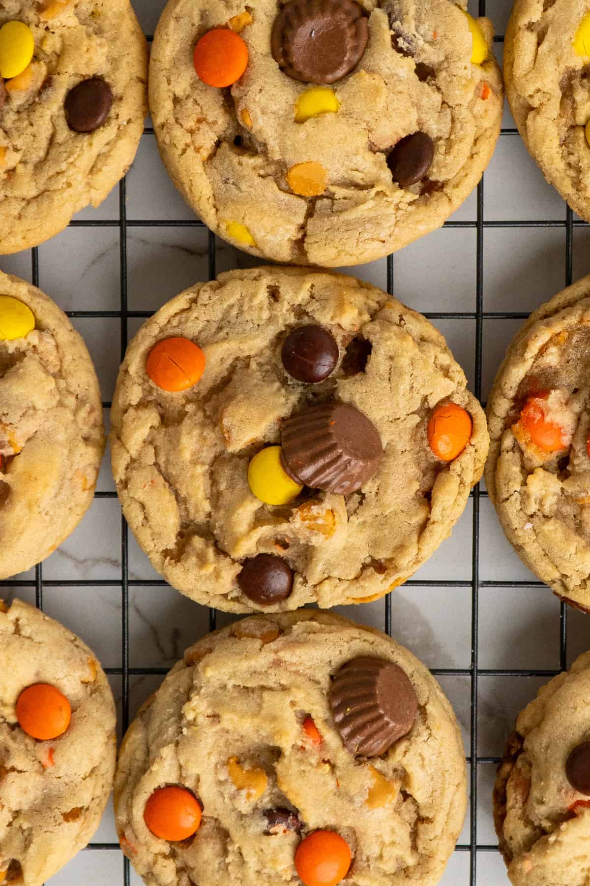 Close-up of Reese's pieces cookies on a cooling rack.