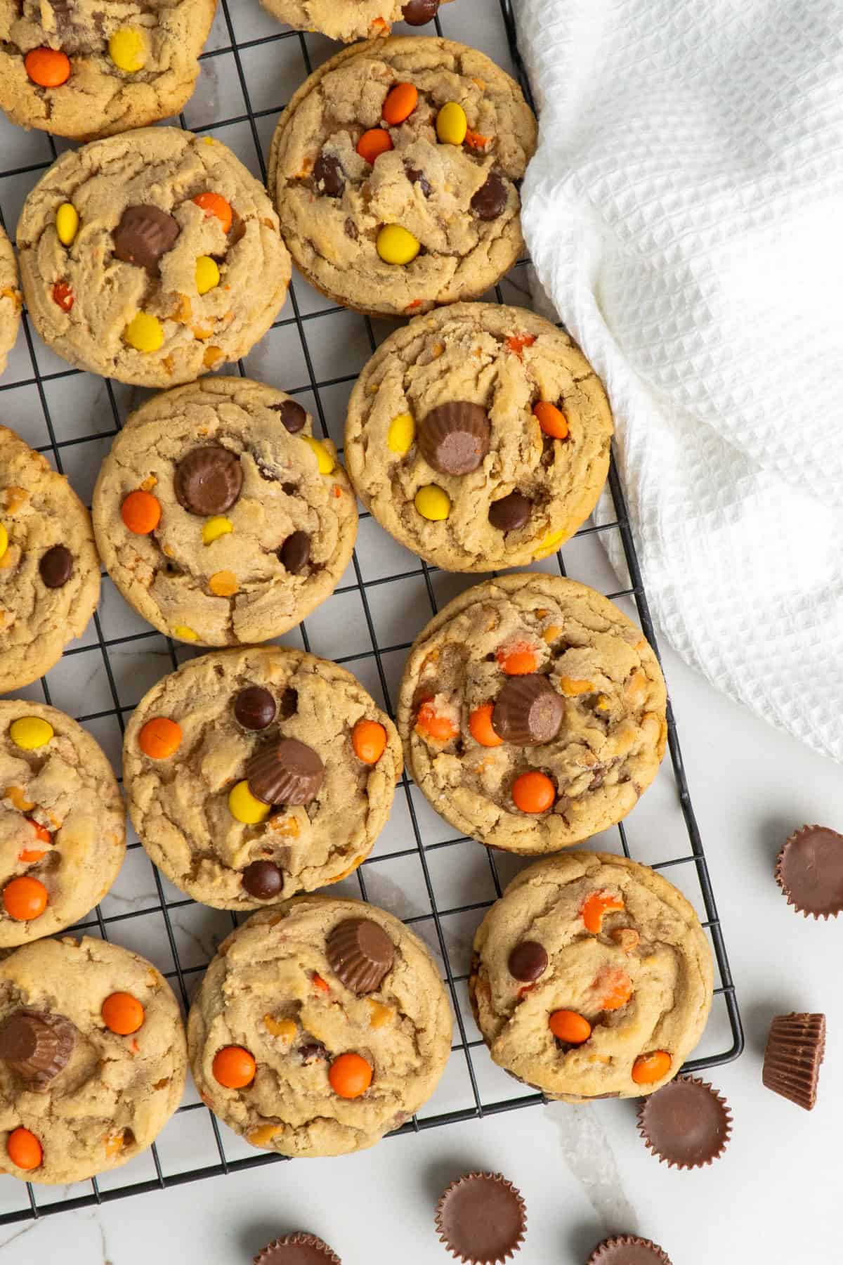 Reese's pieces cookies on a cooling rack.