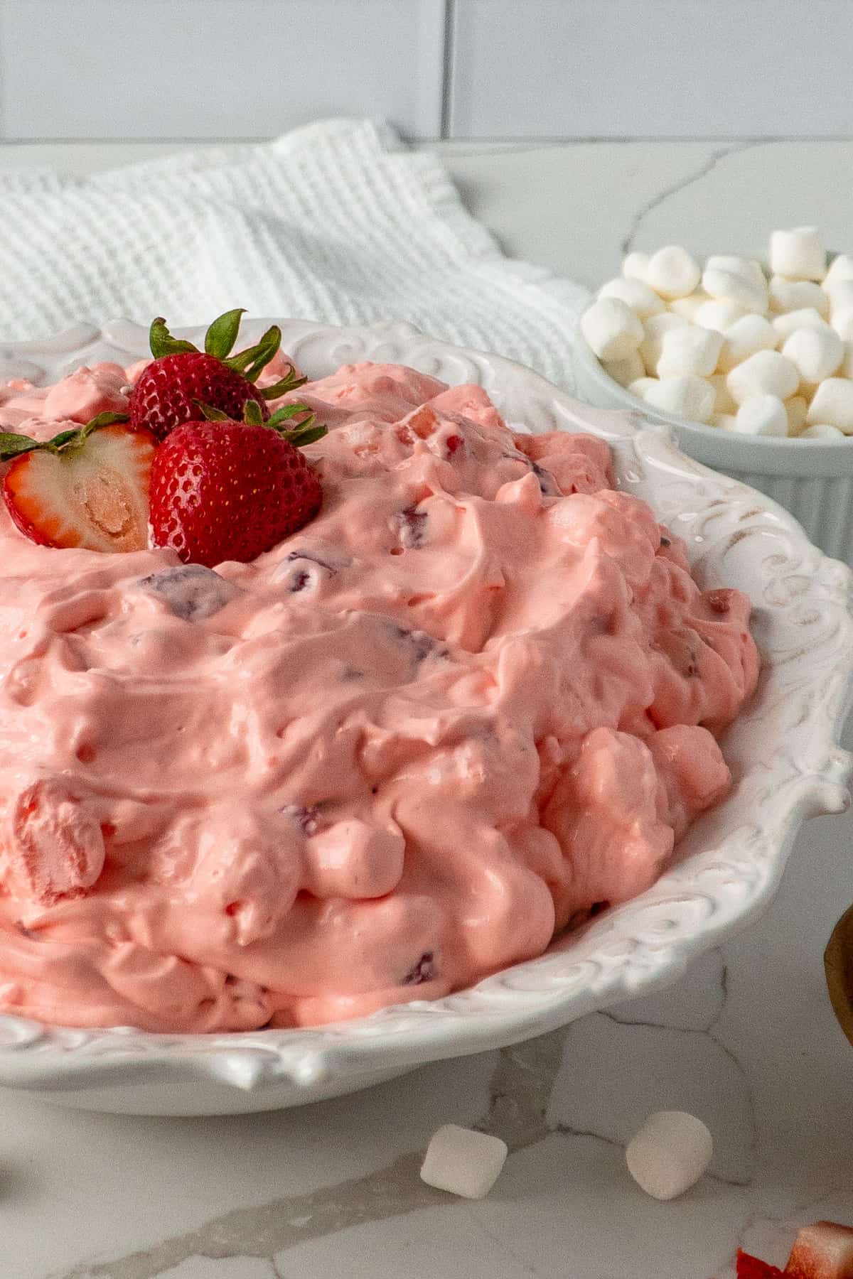 Side view of strawberry fluff salad in a decorative white bowl.