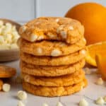 Six orange creamsicle cookies stacked on top of each other.
