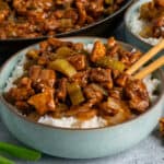 Close-up of Panda Express black pepper chicken over a bowl rice.