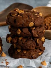 Four chocolate peanut butter chip cookies stacked on top of each other.