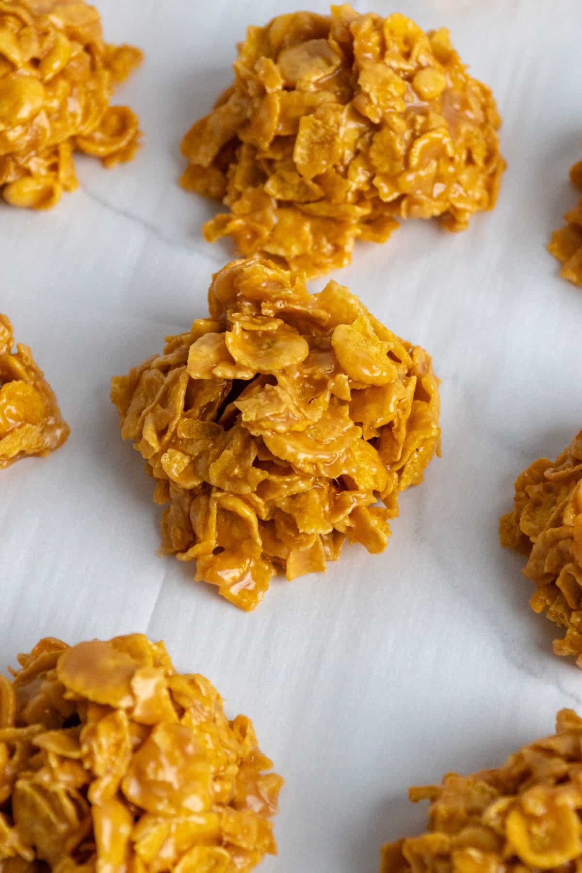 Close-up of peanut butter cornflake cookies on parchment paper.