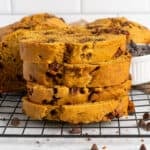 Four pieces of pumpkin chocolate chip bread stacked on top of each other.
