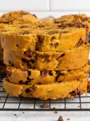 Four pieces of pumpkin chocolate chip bread stacked on top of each other.