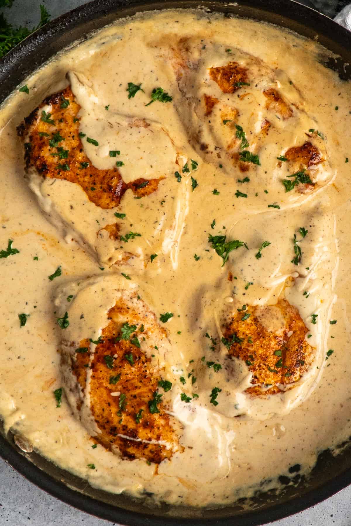 Overhead, look at creamy ranch chicken in a skillet.