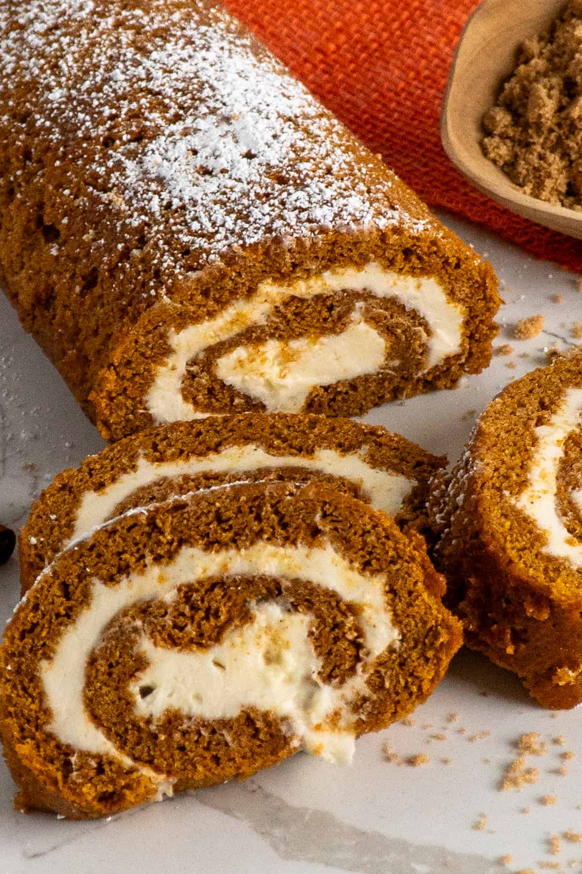 Three pieces of pumpkin roll stack on top of each other.