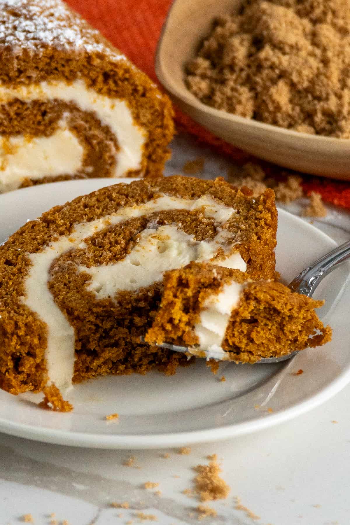 A fork with a bite of pumpkin roll.