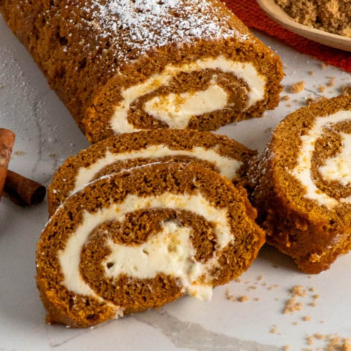 Three pieces of pumpkin roll stack on top of each other.