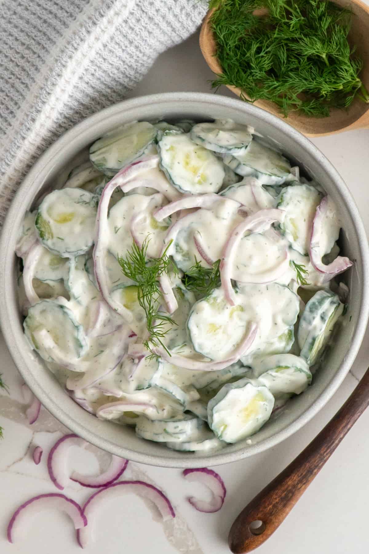 Overhead look at creamy cucumber salad in a bowl.