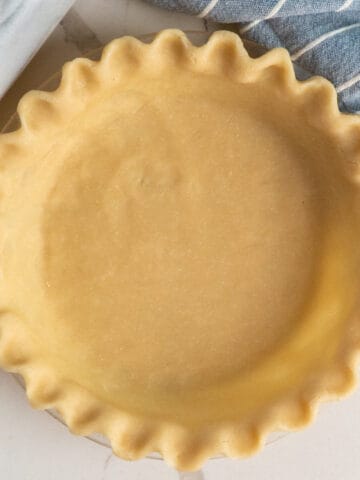 Overhead, look at a uncooked flaky butter pie crust.