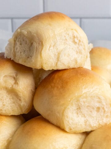 Homemade dinner rolls stacked on top of each other.