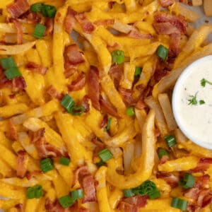 Overhead look of loaded fries on a pan with ranch sauce