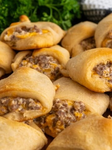 Sausage cream cheese crescent rolls stacked on top of each other.