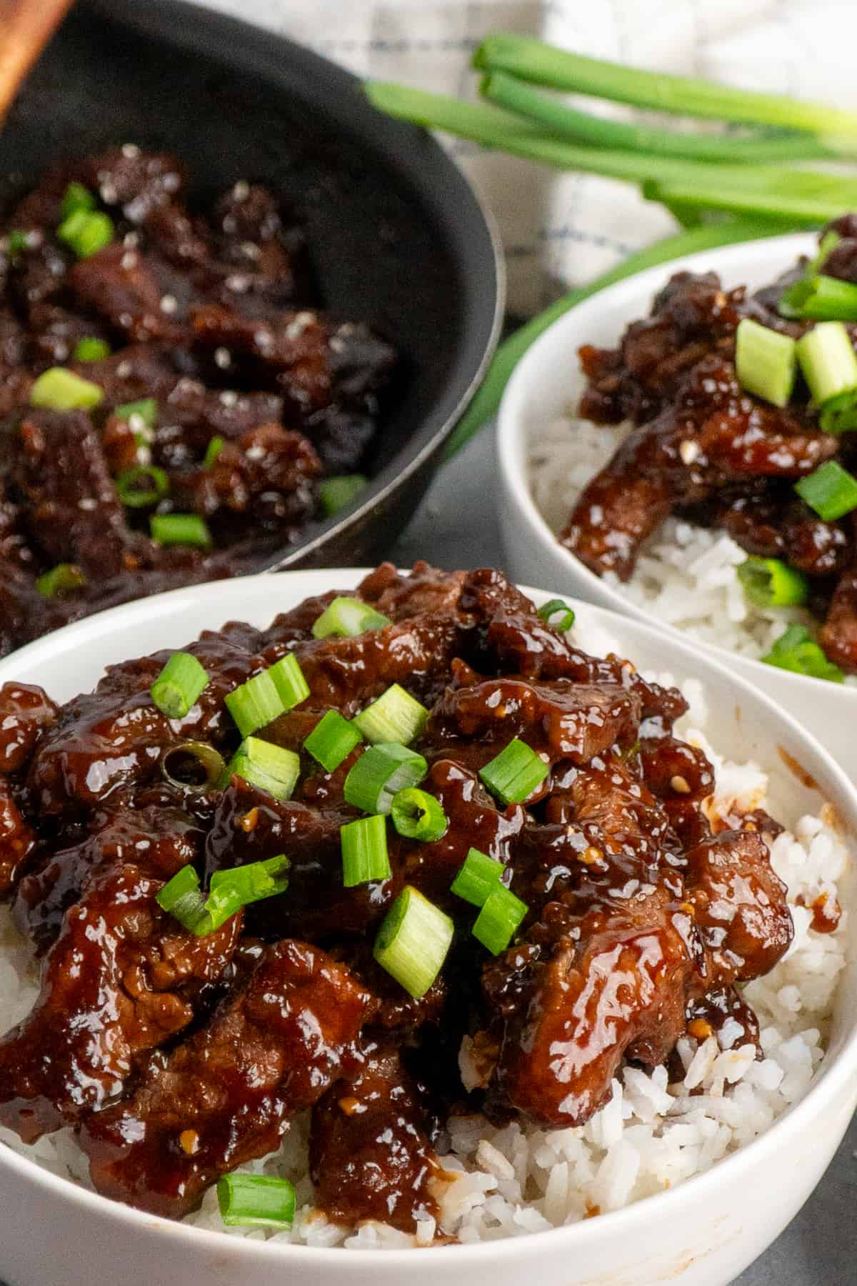 Close-up of beef teriyaki over a bowl of rice.