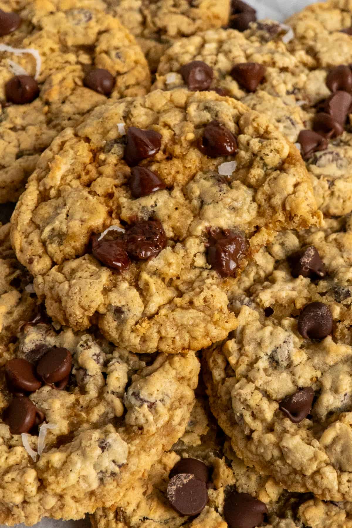 Close up of a chocolate chip cookie with a bite taken out of it.