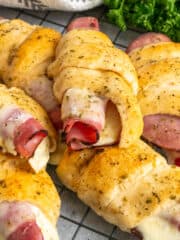 Close-up of ham and cheese crescent rolls on a black cooling rack.