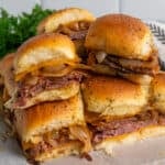 Roast beef sliders stacked on top of each other.