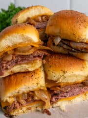 Roast beef sliders stacked on top of each other.