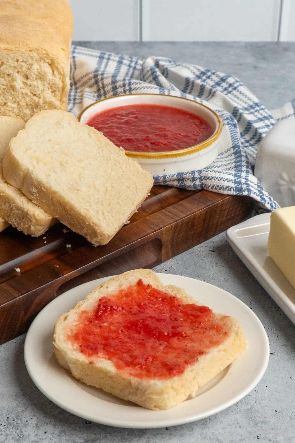 Sandwich bread on a plate with jam on it.