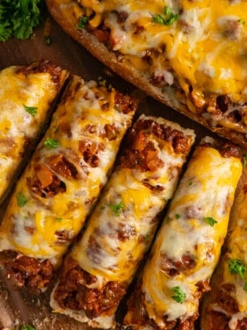 Overhead look at sloppy Joe garlic bread on a wood cutting board.