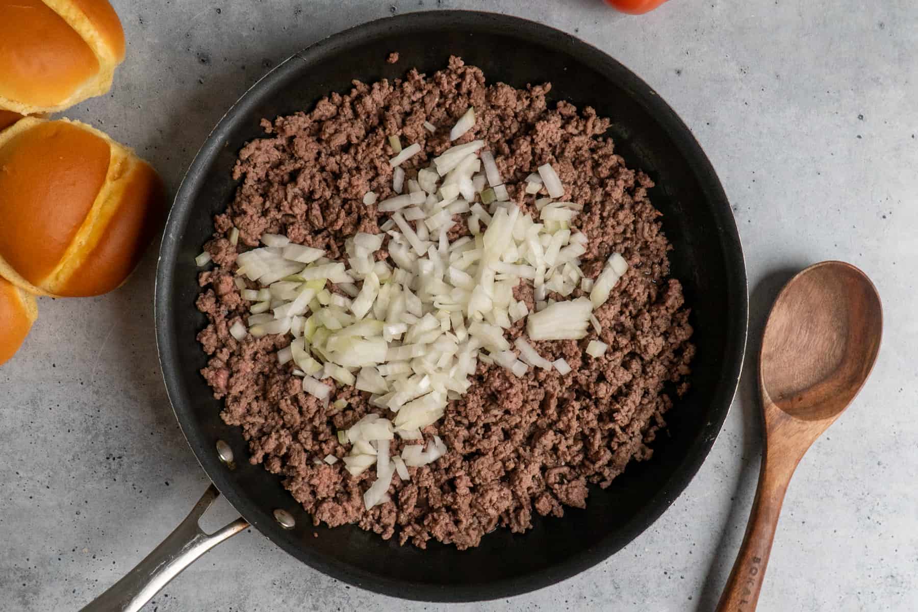 Overhead look at ground beef and onions in a skillet.