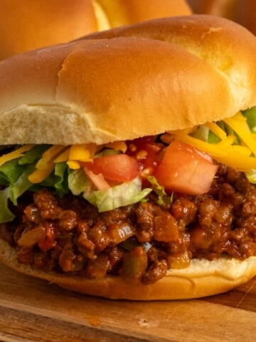 Close up of a taco Joes sandwich on a wood cutting board.
